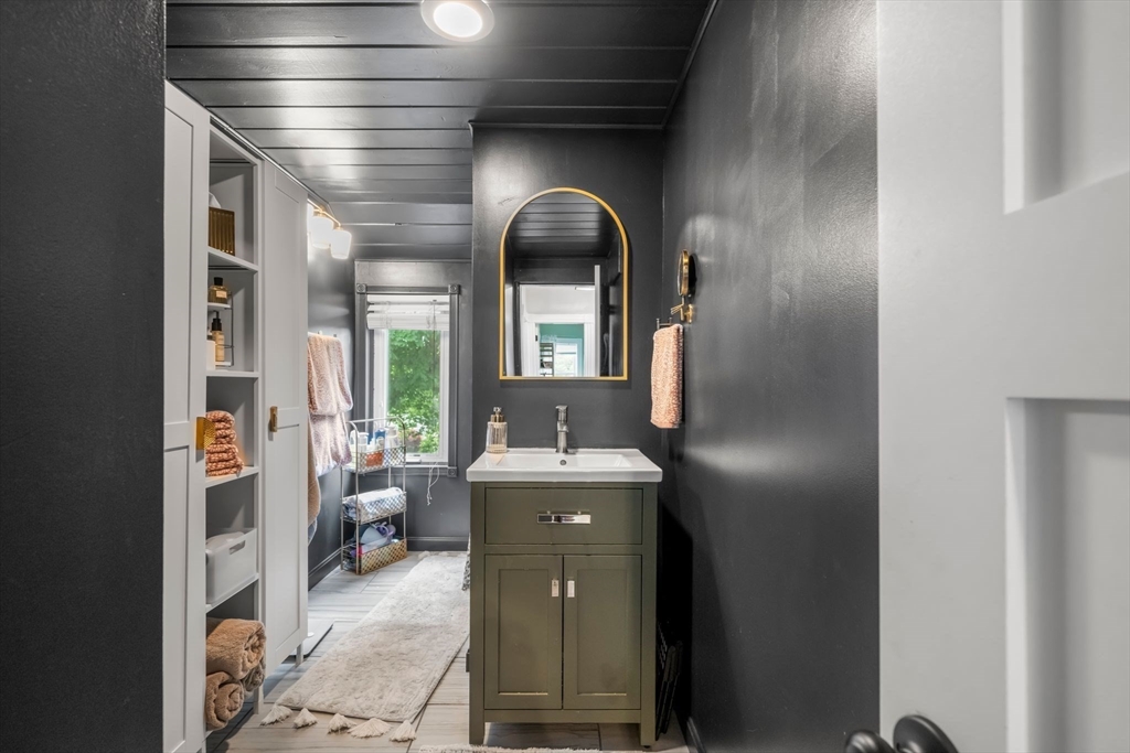 18 Mill Street Boston, MA 02122 - Photo 18 of 38 a living room with a couple of furniture and a large mirror