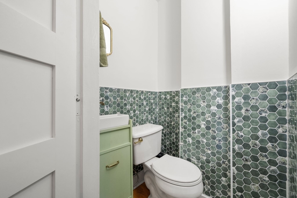 18 Mill Street Boston, MA 02122 - Photo 28 of 38 a white toilet sitting next to a shower curtain