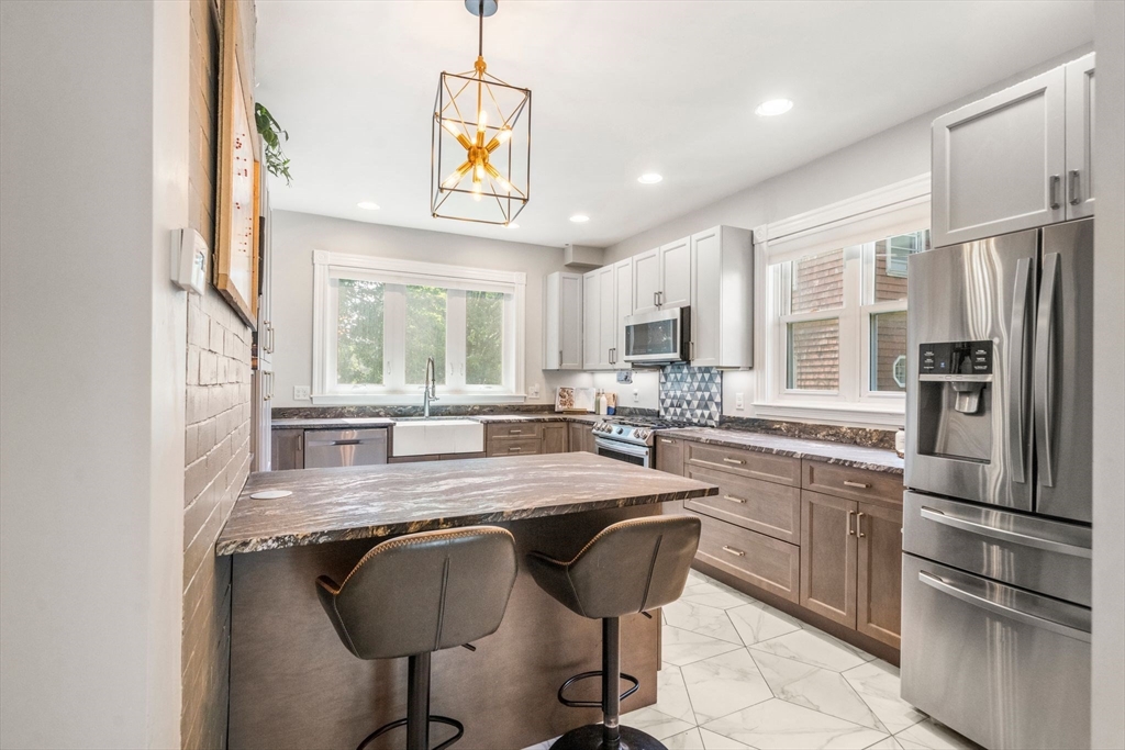 18 Mill Street Boston, MA 02122 - Photo 7 of 38 a kitchen with stainless steel appliances granite countertop a stove a sink and a refrigerator