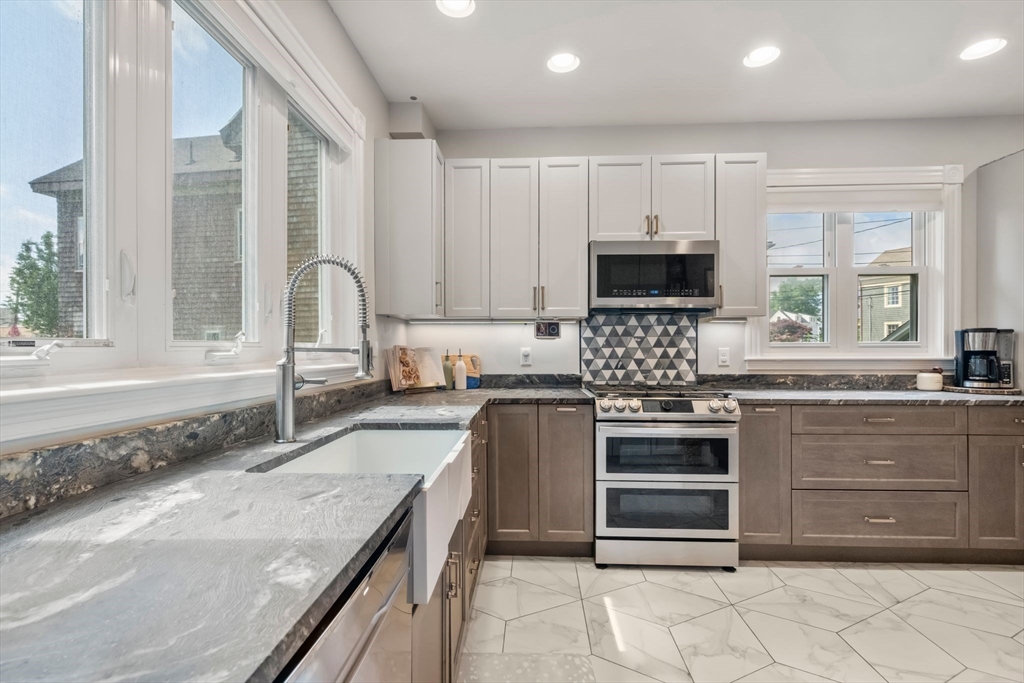 18 Mill Street Boston, MA 02122 - Photo 10 of 38 a kitchen with stainless steel appliances granite countertop a stove sink and cabinets