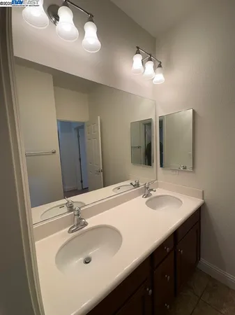 a bathroom with a double vanity sink and a mirror