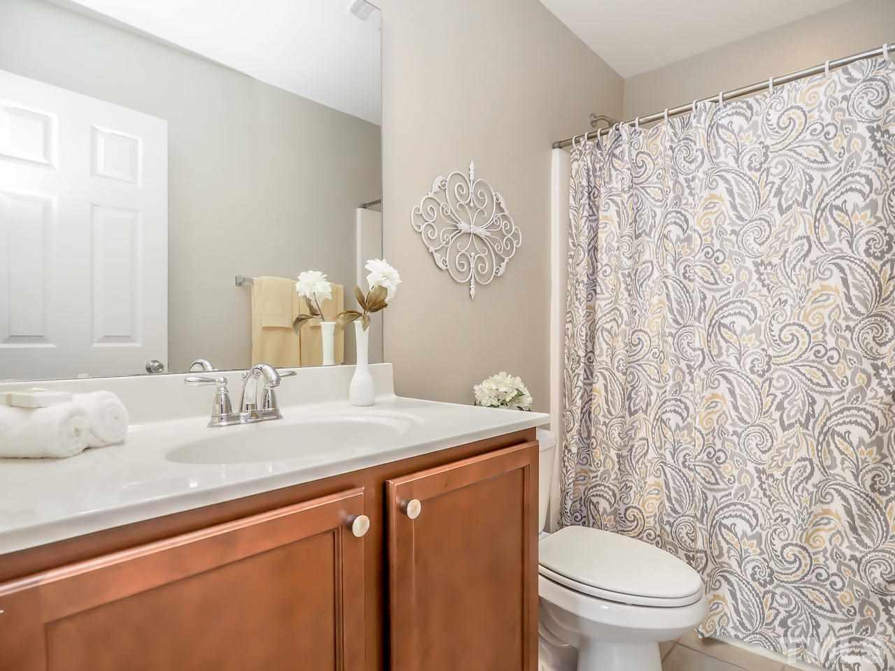 934 Ileagnes Road Raleigh, NC 27603 - Photo 14 of 23 a bathroom with a granite countertop sink a toilet and a mirror