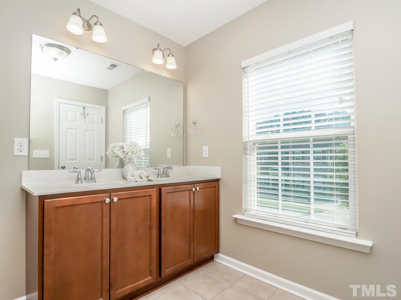 934 Ileagnes Road Raleigh, NC 27603 - Photo 17 of 23 a bathroom with a granite countertop sink and a window