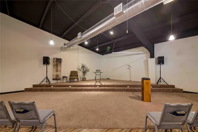 a kitchen with stainless steel appliances kitchen island granite countertop a refrigerator a stove a sink a dining table and chairs with wooden floor