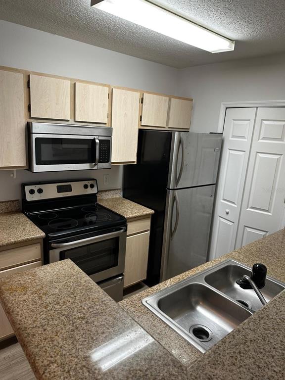 4352 South Kirkman Road, Unit 1204 Orlando, FL 32811 - Photo 15 of 23 a kitchen with a refrigerator sink and microwave