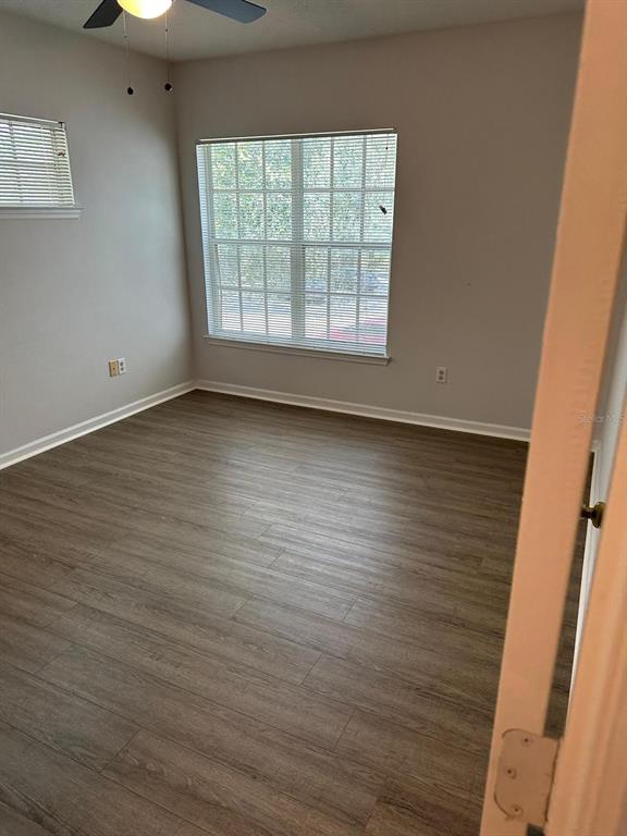 4352 South Kirkman Road, Unit 1204 Orlando, FL 32811 - Photo 10 of 23 an empty room with wooden floor and windows