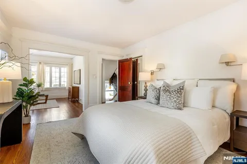 a spacious bedroom with a bed a couch and a potted plant