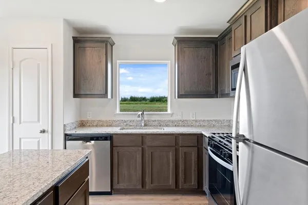 a kitchen with stainless steel appliances granite countertop a sink stove and refrigerator