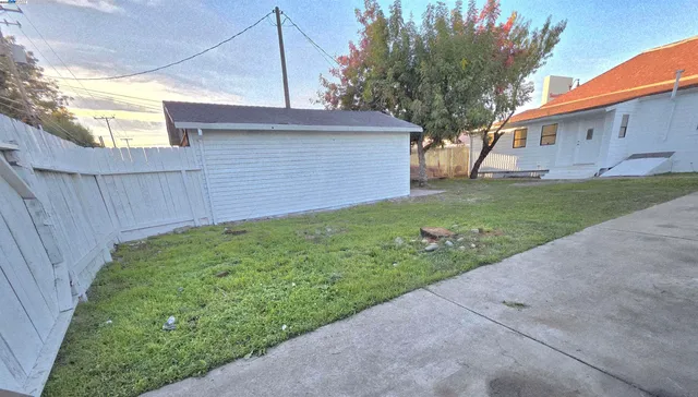 a view of a backyard with wooden fence
