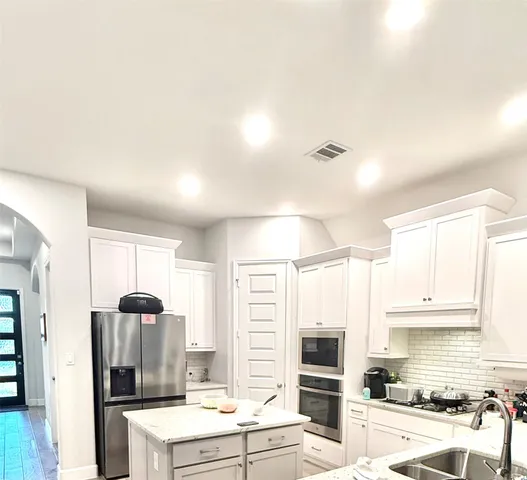 a kitchen with stainless steel appliances granite countertop a stove and a refrigerator