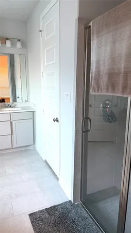 a bathroom with a granite countertop sink a mirror and a shower