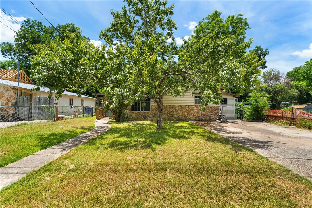 4803 Munson Street Austin, TX 78721 - Photo 1 of 1 a backyard of a house with table and chairs plants and large tree