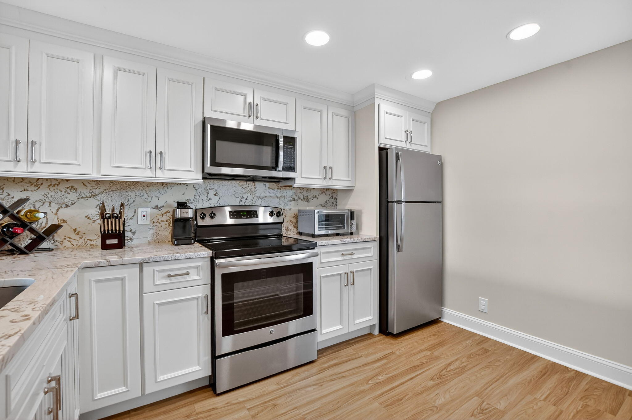 4 Royal Palm Way, Unit 3020 Boca Raton, FL 33432 - Photo 9 of 38 a kitchen with a refrigerator stove and white cabinets