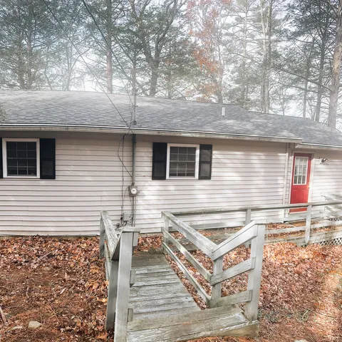 a view of a white house with a sink and wooden floor