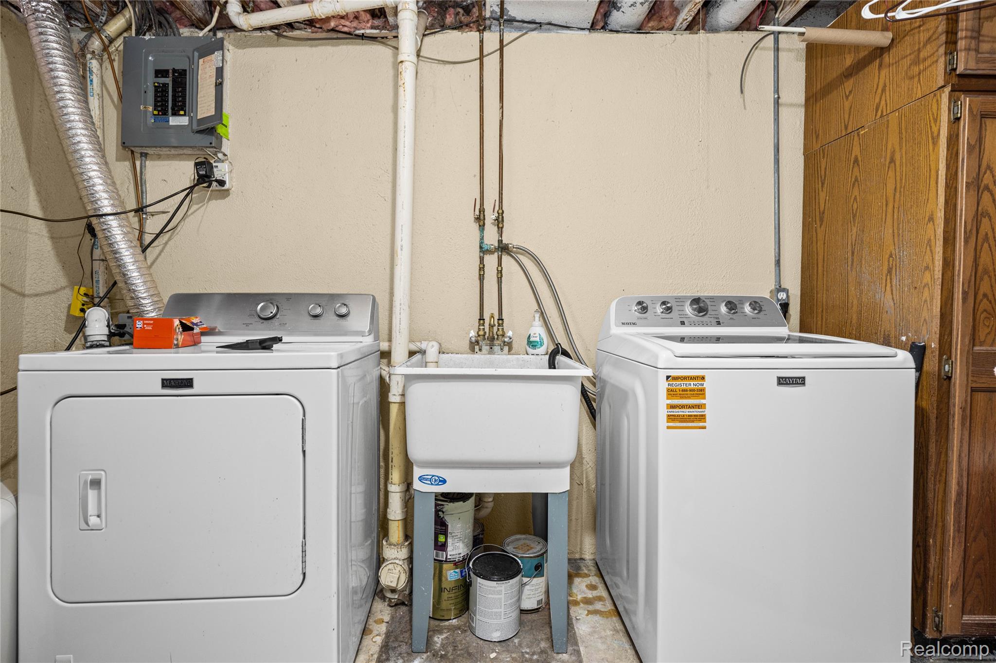 3553 Loon Lake Road Wixom, MI 48393 - Photo 17 of 25 Laundry area featuring a utility sink, electrical panel, and exposed overhead joists