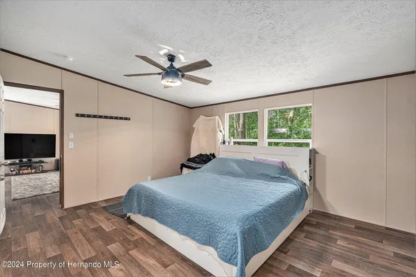 a bedroom with a bed and a ceiling fan