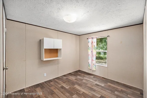a view of a livingroom with wooden floor and a window