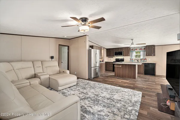 a living room with furniture and kitchen view