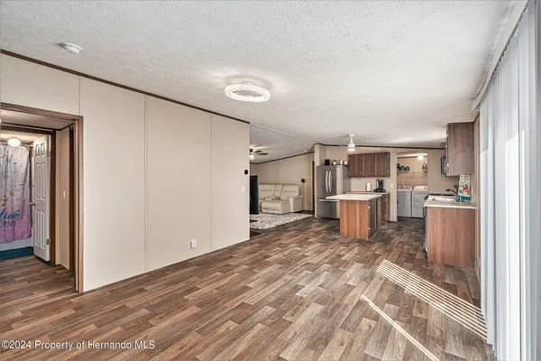 a kitchen with a refrigerator oven a sink dishwasher and wooden cabinets with wooden floor