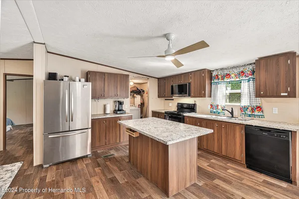 a kitchen with granite countertop a sink stove and refrigerator