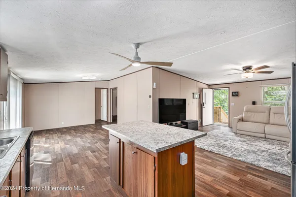 a bedroom with a large bed and a flat tv screen on dresser