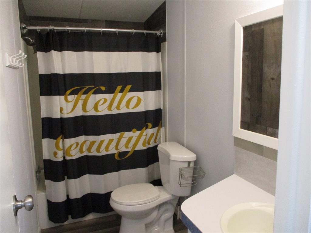 1336 Rains County Road 1530 Point, TX 75472 - Photo 25 of 26 a bathroom with a toilet and a shower curtain