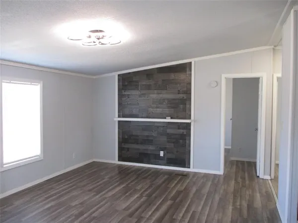 a view of empty room with wooden floor and window