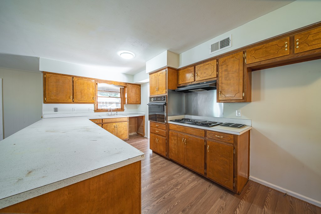 6411 Michael Avenue Columbus, GA 31909 - Photo 22 of 34 a kitchen with stainless steel appliances granite countertop a sink a stove and a wooden floors