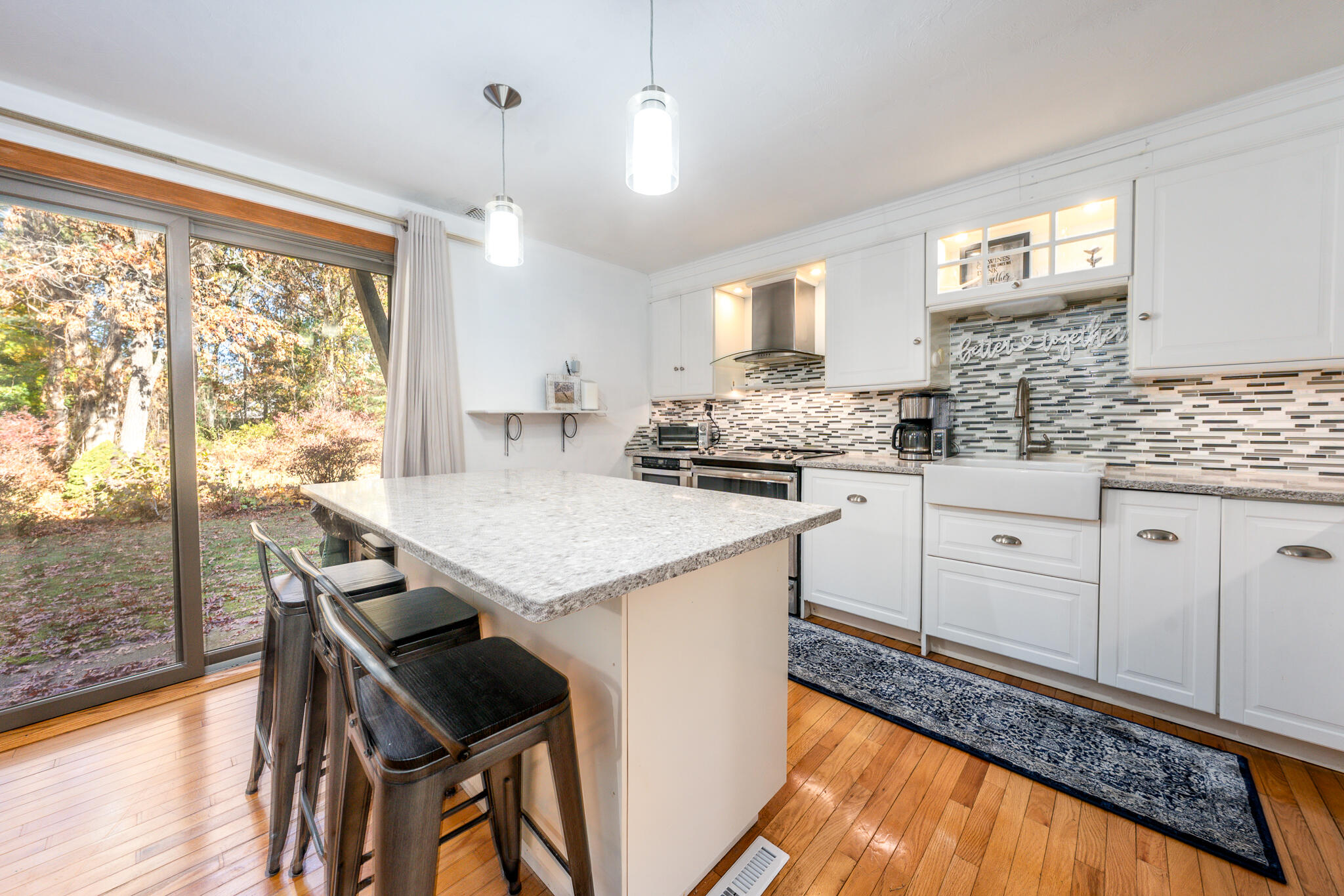 195 Falmouth Road, Unit 9D Mashpee, MA 02649 - Photo 10 of 36 a kitchen with granite countertop white cabinets and wooden floor