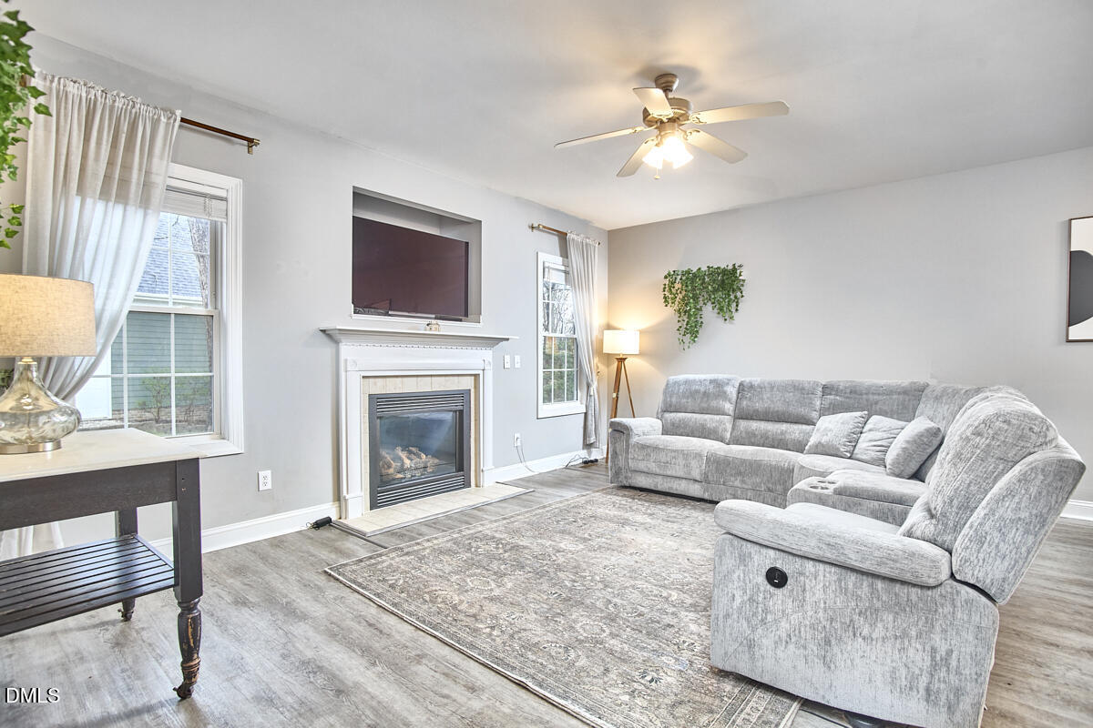 3821 La Costa Way Raleigh, NC 27610 - Photo 13 of 45 a living room with furniture a fireplace and a flat screen tv