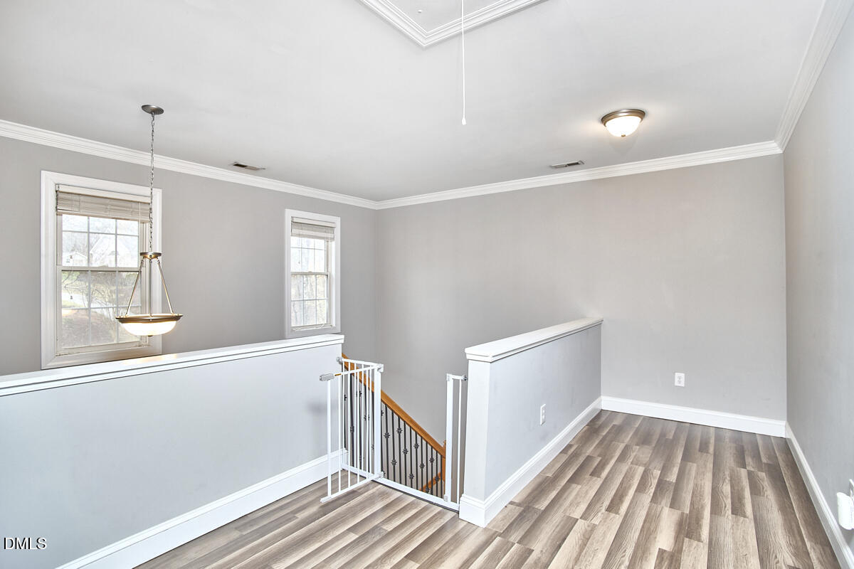 3821 La Costa Way Raleigh, NC 27610 - Photo 21 of 45 a view of an empty room with wooden floor and a window