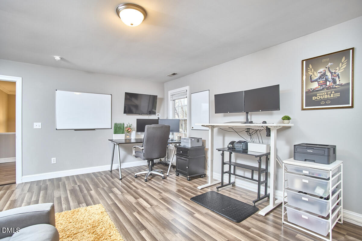 3821 La Costa Way Raleigh, NC 27610 - Photo 25 of 45 a workspace with a computer on a desk and a book shelf
