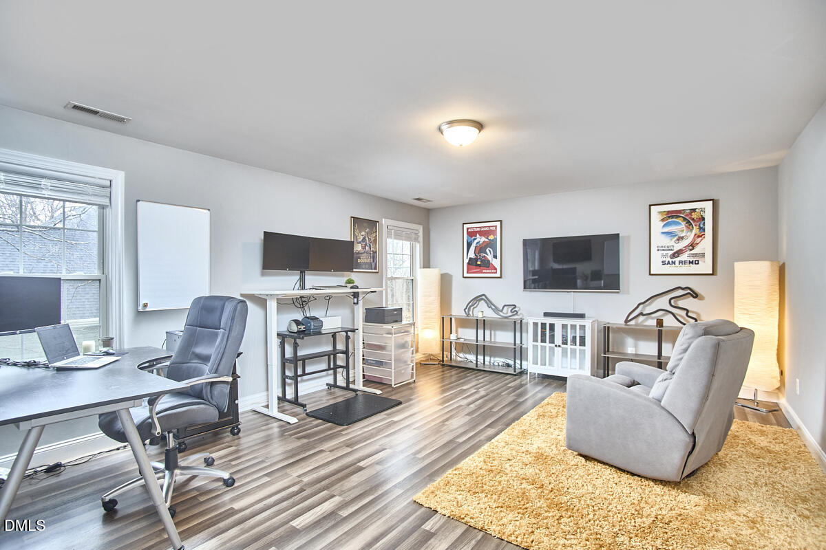3821 La Costa Way Raleigh, NC 27610 - Photo 27 of 45 a living room with furniture a flat screen tv and a fireplace