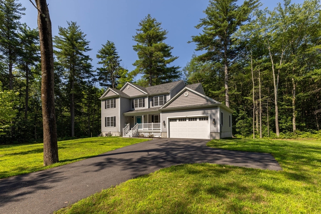 a front view of a house with a yard and trees