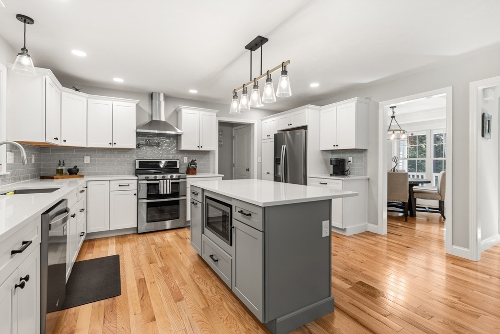 62 Benjamin Road Shirley, MA 01464 - Photo 6 of 37 a kitchen with stainless steel appliances kitchen island granite countertop a stove a sink a refrigerator and white cabinets with wooden floor