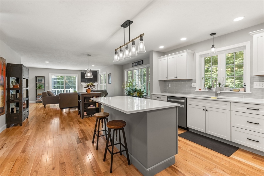 62 Benjamin Road Shirley, MA 01464 - Photo 10 of 37 a kitchen with stainless steel appliances granite countertop wooden floors a stove and white cabinets