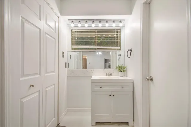 a bathroom with a granite countertop sink a mirror and a bathtub