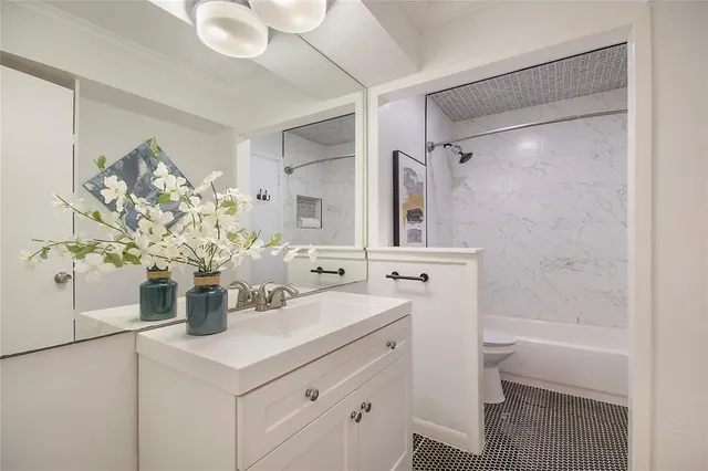 a bathroom with a sink a toilet and shower