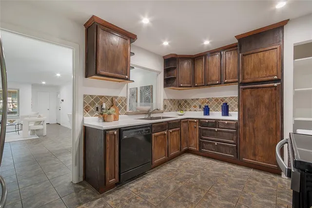 a kitchen with granite countertop a refrigerator stove top oven and sink