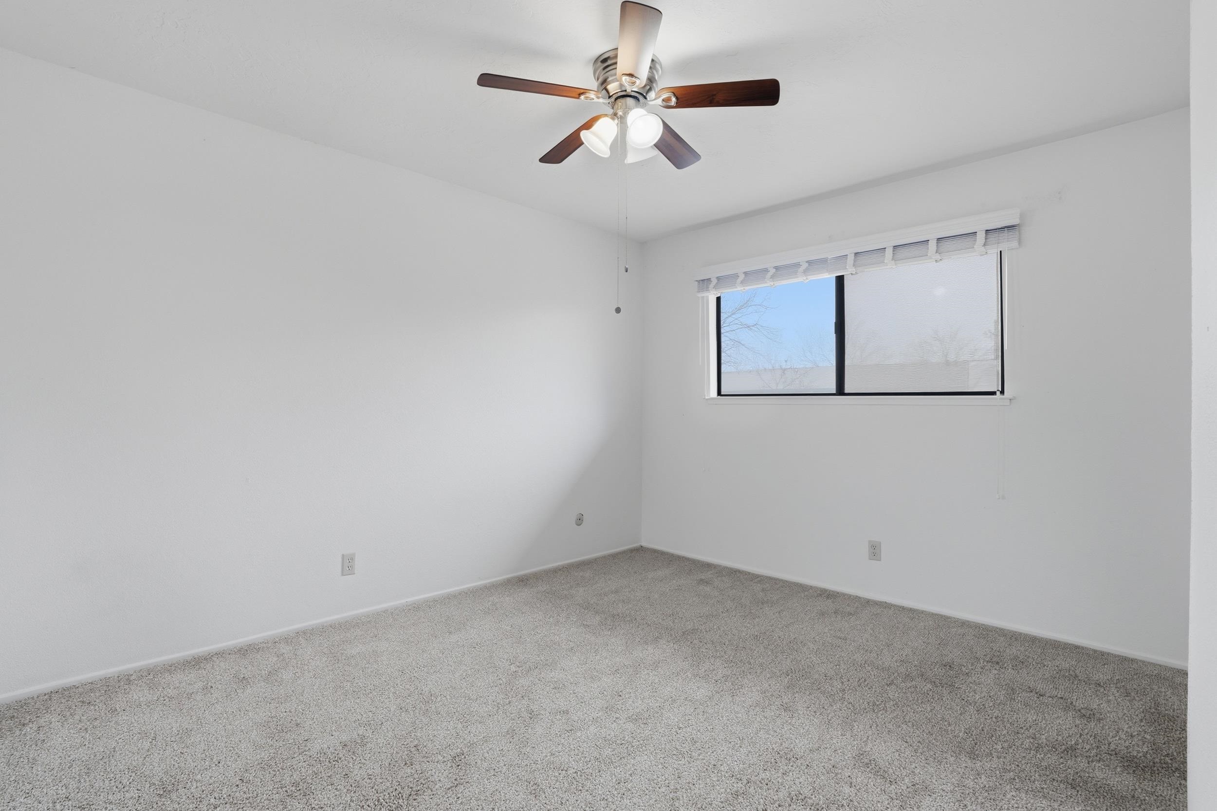 3401 Bermuda Avenue, Unit 6 Davis, CA 95616 - Photo 26 of 43 an empty room with a chandelier fan and windows