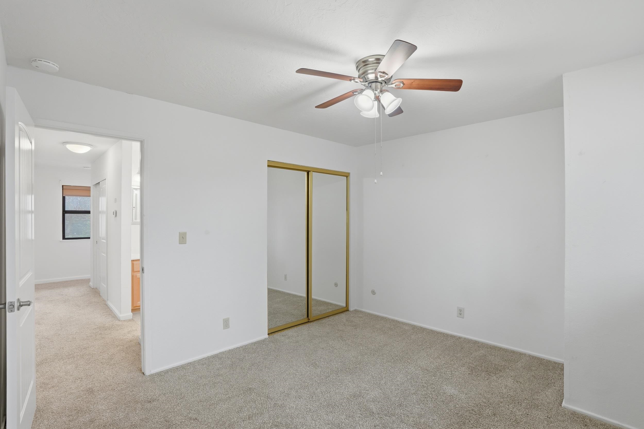 3401 Bermuda Avenue, Unit 6 Davis, CA 95616 - Photo 35 of 43 an empty room with windows and chandelier fan