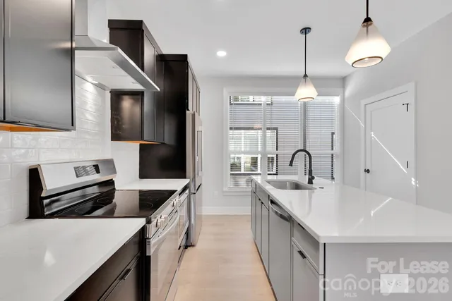 a kitchen with refrigerator and chairs