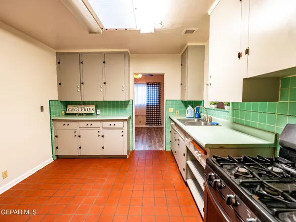 a kitchen with stainless steel appliances a stove a sink and a refrigerator