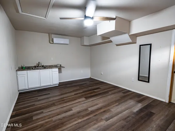 a view of an empty room with wooden floor
