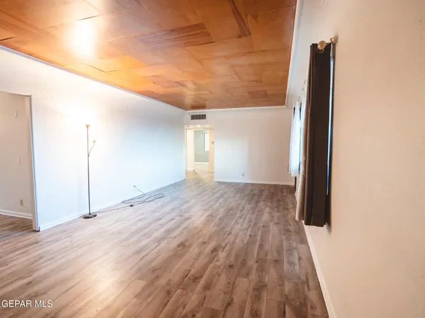 a view of a hallway with wooden floor and cabinet