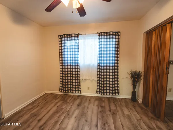 an empty room with fan and windows
