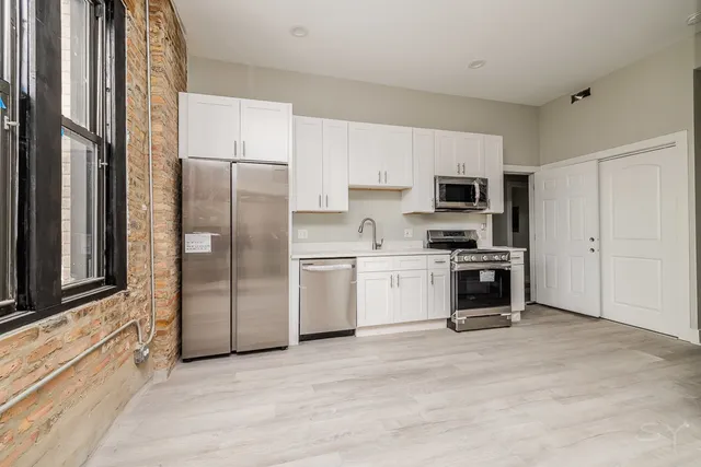 a kitchen with white cabinets and stainless steel appliances