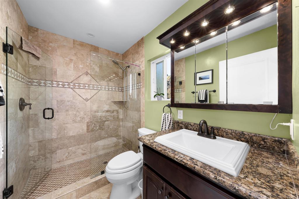 4711 Lorena Place El Cajon, CA 92020 - Photo 13 of 33 a bathroom with a granite countertop sink a toilet and shower