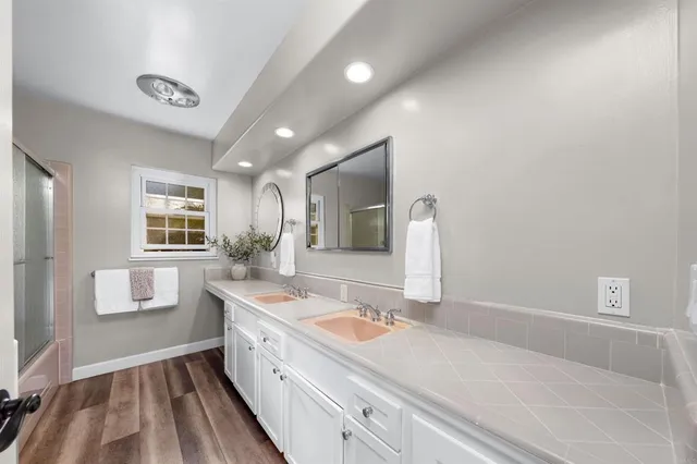a bathroom with a sink a large mirror and a bathtub