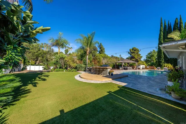 a view of a house with swimming pool and sitting area